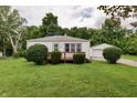 Quaint single-story home with a well-maintained lawn, mature trees, and a detached garage at 1727 S Irvington Ave, Indianapolis, IN 46203