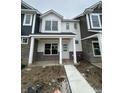 Charming townhome with white siding, stone accents, covered porch, and sidewalk at 19571 Grassy Branch Dr, Westfield, IN 46074