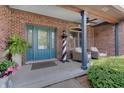 Cozy porch area with a light house, wicker chairs, and a turquoise door at 214 W Stoney Trl, Greenfield, IN 46140