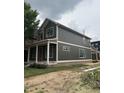 Two-story home with dark green siding and white trim, complemented by a covered front porch, set on a spacious lot at 2148 N Pennsylvania St, Indianapolis, IN 46202