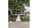 Inviting two-story home with a welcoming front porch, lush landscaping, and a sidewalk leading to the entrance at 2148 N Pennsylvania St, Indianapolis, IN 46202