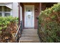Inviting front entrance with a decorative storm door, brick accents, and manicured shrubs along the walkway at 2309 Maple St, Columbus, IN 47201