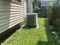 Air conditioning unit, and overgrown grass, on the side of the home at 24 Hendricks Pl, Indianapolis, IN 46201