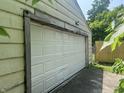 White garage with paneled door and wooden trim, next to the house at 24 Hendricks Pl, Indianapolis, IN 46201