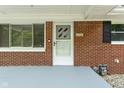 Close up of the brick-lined front porch and front door featuring modern house number at 258 N Green Springs Rd, Indianapolis, IN 46214
