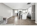 Open-concept kitchen and dining area with laminate floors, white cabinets, and stainless steel appliances at 258 N Green Springs Rd, Indianapolis, IN 46214