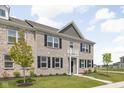 Attractive townhouse showcasing a classic design with a small front balcony and tidy landscaping at 2892 Maricopa Blvd, Whitestown, IN 46075