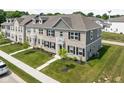 Beautiful townhome featuring a well-manicured lawn, classic brick facade, and modern black shutters at 2892 Maricopa Blvd, Whitestown, IN 46075