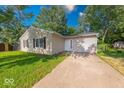 A cozy one-story home featuring a well-manicured lawn and concrete driveway at 3817 Strathmore Dr, Indianapolis, IN 46235