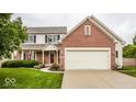 Two-story home with brick and siding, featuring an attached garage and a well-maintained lawn with shrubs at 3823 Vanguard Cir, Carmel, IN 46032