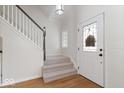 Bright foyer with staircase, hardwood floors, and a decorative front door with leaded glass at 3823 Vanguard Cir, Carmel, IN 46032