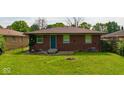 A view of the backyard of the house showing the lawn, the back of the house, and the surrounding properties at 3922 N Irvington Ave, Indianapolis, IN 46226