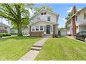 Charming two-story home featuring a well-manicured lawn, inviting front porch, and a classic facade at 4002 Guilford Ave, Indianapolis, IN 46205