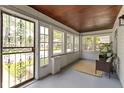Inviting front porch with a seating area, wood ceilings, large windows, and a secure front door at 4002 Guilford Ave, Indianapolis, IN 46205