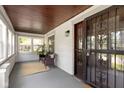 Inviting front porch with a seating area, wood ceilings, large windows, and a secure front door at 4002 Guilford Ave, Indianapolis, IN 46205