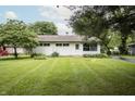 Charming home featuring a well-manicured lawn, mature trees, and a cozy exterior at 4020 Alden Ave, Indianapolis, IN 46221