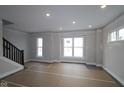 Spacious living room featuring large windows and a staircase with dark railing at 4181 Barrel Ln, Westfield, IN 46062