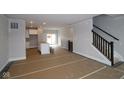 Open-concept living space with access to kitchen and staircase with dark railing at 4181 Barrel Ln, Westfield, IN 46062