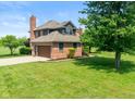 Brick home with attached garage, a well-maintained lawn, and beautiful mature landscaping at 4287 Gibbs Rd, Danville, IN 46122