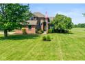 Beautiful brick home showcases a lush green lawn and mature trees at 4287 Gibbs Rd, Danville, IN 46122