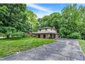Two-story home with mature trees and a long driveway leading to the attached garage at 4570 Moccosin Pl, Greenwood, IN 46142