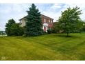 A two-story home boasts a well-kept lawn and mature landscaping, offering curb appeal with natural beauty at 4617 S Cobblestone Dr, Zionsville, IN 46077