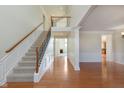 Bright foyer featuring hardwood floors, staircase, and views to the living areas at 4617 S Cobblestone Dr, Zionsville, IN 46077