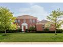 Beautiful two-story brick home with a manicured lawn and bright red front door at 4617 S Cobblestone Dr, Zionsville, IN 46077