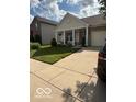 Home featuring a covered porch, manicured lawn, and a two-car garage at 5304 Appleseed Way, Indianapolis, IN 46217