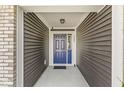 Inviting entryway with a striking blue front door, complemented by wood siding and a covered porch at 5409 Brandywine Dr, Whitestown, IN 46075