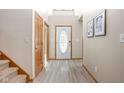 Bright foyer with wood-look floors, stairs and decorative front door at 5695 N Red Oak Dr, Greenfield, IN 46140