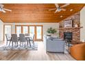 Open living room with a fireplace, wood-paneled ceiling, and access to outdoor area at 5695 N Red Oak Dr, Greenfield, IN 46140