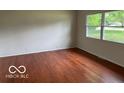 Bright living room boasting gleaming hardwood floors and a large window at 618 W Mckenzie Rd, Greenfield, IN 46140