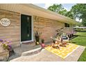 Charming front entrance featuring a seating area and green door at 6464 Whitley Ln, Indianapolis, IN 46260