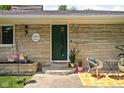 Charming front entrance featuring a green door, seating area and plants at 6464 Whitley Ln, Indianapolis, IN 46260
