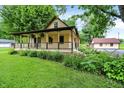 Beautiful home with a welcoming front porch, complemented by well-maintained landscaping at 6644 Mcfarland Rd, Indianapolis, IN 46227