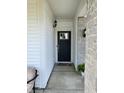 Close-up of front door framed by stone pillars, black hardware, and tasteful outdoor lighting at 6731 Keepsake Dr, Whitestown, IN 46075