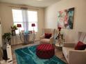 Cozy living room featuring accent chairs, a plush ottoman, and decorative accents at 6731 Keepsake Dr, Whitestown, IN 46075