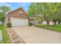 This home features a brick exterior, a well-manicured lawn, and a two-car garage at 8315 Exton Rd, Indianapolis, IN 46239