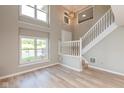 The living room has new vinyl flooring, a staircase, and lots of light at 8955 Stonegate Rd # A, Indianapolis, IN 46227