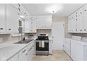 Cozy kitchen with white cabinetry, stainless steel appliances, and a laundry area at 1010 Maple St, Greenwood, IN 46142
