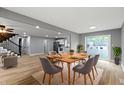 Open-concept dining area with stylish table set and views into the kitchen and living room at 10398 Ethel St, Carmel, IN 46280