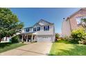 Traditional two-story home with a front porch, attached garage, and a well-manicured lawn at 10900 Clear Spring Dr, Camby, IN 46113