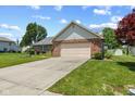 A beautiful brick home features a two-car garage, mature trees, and a well-maintained lawn at 11026 Clearspring Way, Indianapolis, IN 46239