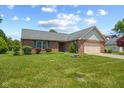 This brick home offers an attached garage, complemented by a lush front yard and manicured landscaping at 11026 Clearspring Way, Indianapolis, IN 46239