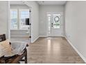 Bright foyer with wood floors, white front door, and views into other rooms at 11809 Redpoll Trl, Noblesville, IN 46060