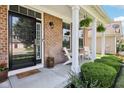 Welcoming front porch with white columns, hanging ferns, seating and lovely landscaping at 123 Bentree Blvd, Danville, IN 46122