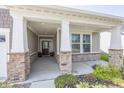 Welcoming covered front porch with stone pillars, manicured flower beds, and stylish entry door creates inviting curb appeal at 1283 Clairet, Westfield, IN 46074