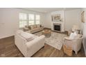 Bright living room featuring neutral furniture, fireplace, large windows, and hardwood flooring for a warm and inviting atmosphere at 1283 Clairet, Westfield, IN 46074