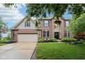 Charming brick two-story home featuring a large driveway and attached two-car garage at 1345 Lewiston Dr, Westfield, IN 46074